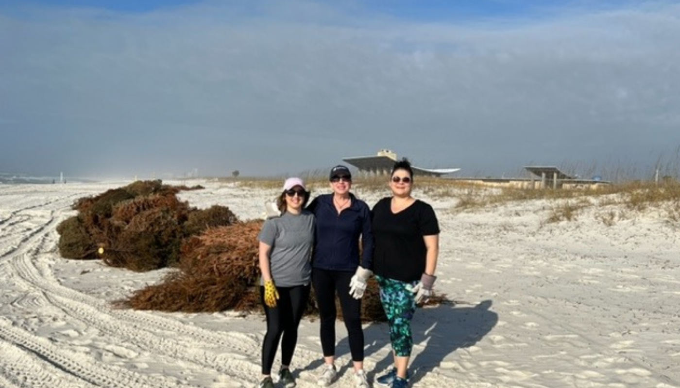 members of the kaiser vacation rentals team standing on the beach at Gulf State Park in alabama